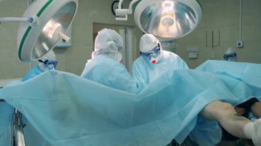 Operasyon güvenlik giysileri içinde doktorlar tarafından yürütülüyor. Coronavirüs salgını, covid-19 konsepti.