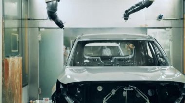 Robot silah spreyi araba üretim tesisinde bir araç cesedi boyuyor.