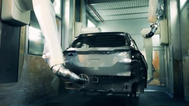 Роботизированный спрей для рук окрашивает тело автомобиля в черный цвет на заводе по производству автомобилей — стоковое видео
