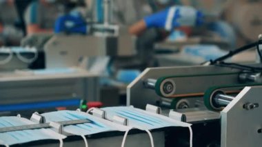 Birden fazla tıbbi maskesi olan fabrika taşıyıcısı.