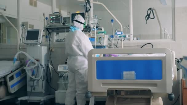 Infirmière prenant soin d'un patient atteint de covidé-19 dans un lit de soins intensifs — Video