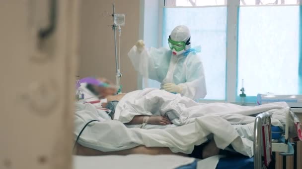 Професіонал охорони здоров'я жінки лікує хворого на коронавірус — стокове відео