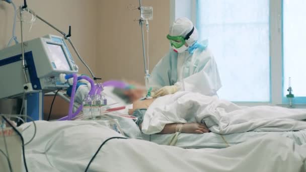 Enfermeira cuidando de um paciente coronavírus em um centro médico — Vídeo de Stock