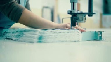 Kumaş ustura kullanan bir fabrika çalışanı tarafından kesiliyor.