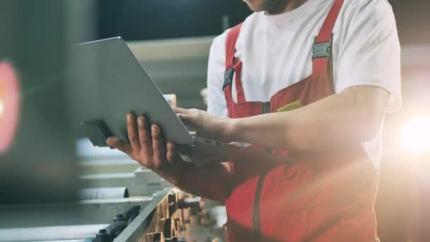 Industriële transportband en een mannelijke ingenieur met een laptop — Stockvideo