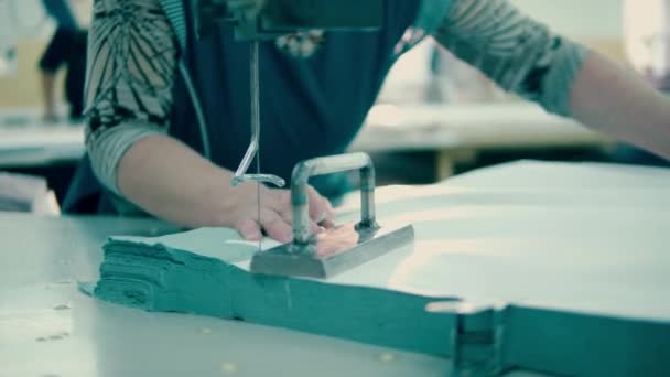 Pracovník továrny používá krájecí mechanismus k řezání kousků tkaniny — Stock video