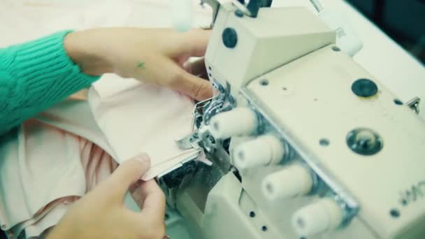 Employé de l'usine utilise une machine à coudre des morceaux de vêtements — Video