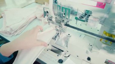 Kumaş, kadın bir çalışan tarafından mekanik olarak dikiliyor.