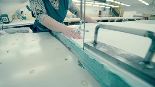 Empleado de fábrica está cortando tela con una herramienta de afeitar — Vídeo de stock