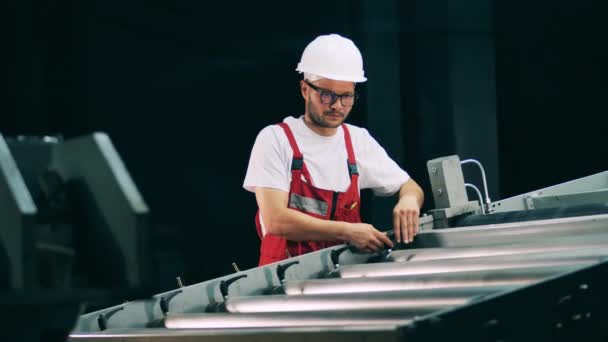 Male engineer is adjusting an industrial conveyor — Stock Video