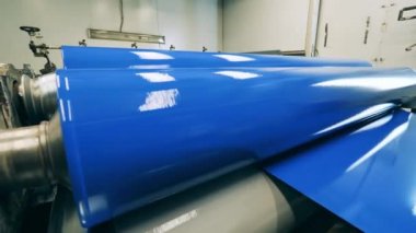 Renkli metal, yuvarlanan taşıyıcıdan geçiyor.