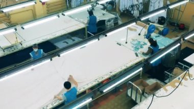 Kumaşla çalışan çalışanları olan bir giyim fabrikası.
