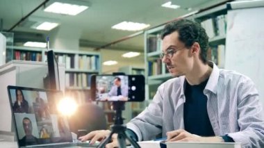 Erkek kütüphaneci online bir ders veriyor.