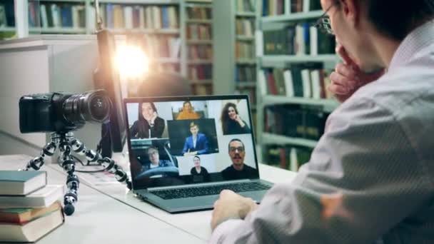 Exibição de computador durante a aula multiusuário online realizada em uma biblioteca — Vídeo de Stock