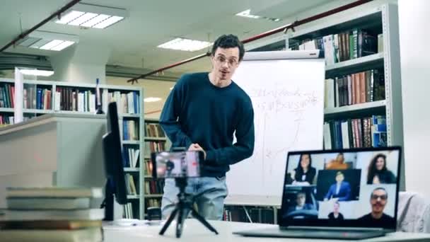 Bibliotecario masculino está enseñando una lección en línea para adultos — Vídeo de stock