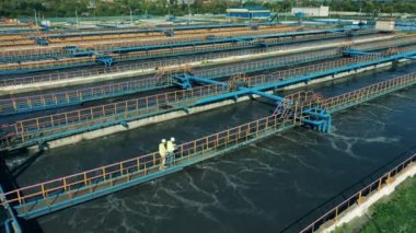 İki erkek uzman modern bir atık su arıtma tesisini inceliyor.