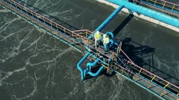 Снимок с воздуха двух операторов сточных вод на объекте очистки сточных вод — стоковое видео