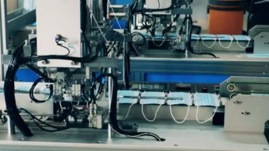 Bir tıbbi maske üretim fabrikasında modern yüz maskesi üretim makineleri