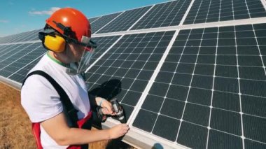 Güneş paneli teknisyeni güneş enerjisi tesisinde güneş paneli kuruyor. Alternatif, yeşil enerji işçisi.