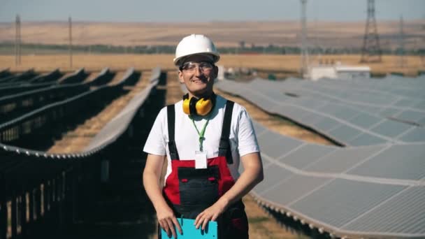 Trabajador de la industria de energía solar de pie en un parque solar. Trabajador alternativo de energía verde. — Vídeo de stock