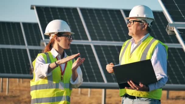 Två solenergispecialister talar på en solpanel anläggning — Stockvideo