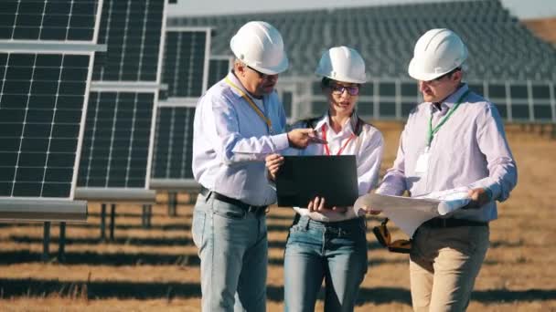 Equipe de engenheiros de energia monitorando uma usina fotovoltaica. Conceito de energia solar. — Vídeo de Stock