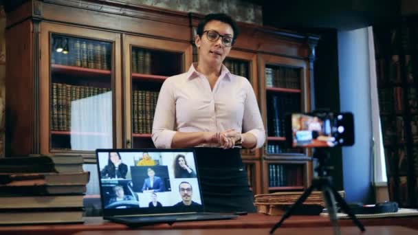 Una mujer está dando una clase de internet en la biblioteca — Vídeos de Stock