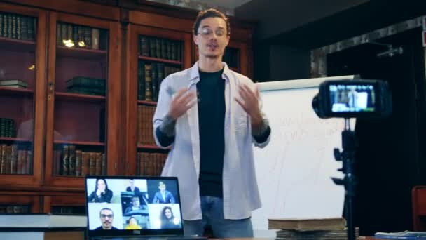 Manlig lärare genomför en videoklass i biblioteket — Stockvideo