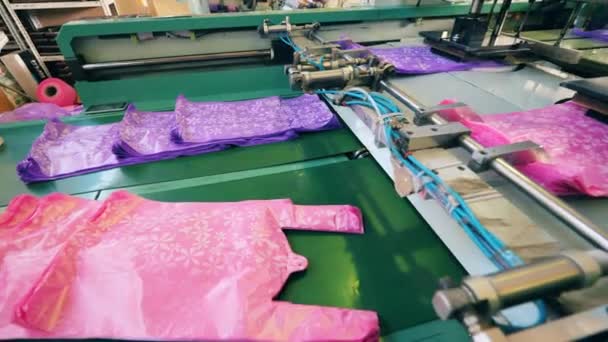 Gekleurde polyethyleen zakken worden vrijgegeven door de transporteur — Stockvideo