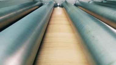 Tahta kaplamalı metal levha silindirler arasında hareket ediyor