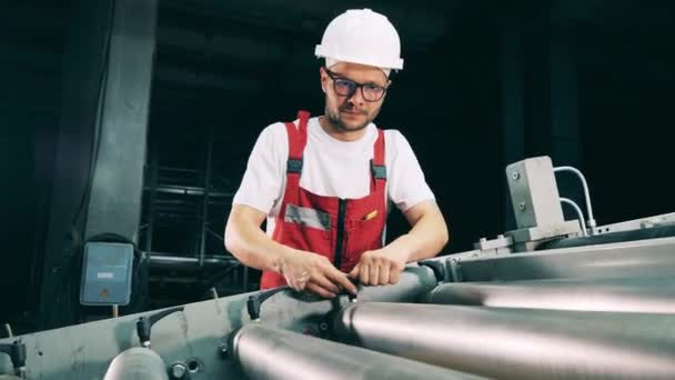 Worker regulating pressure rollers at rolling mill — Stock Video