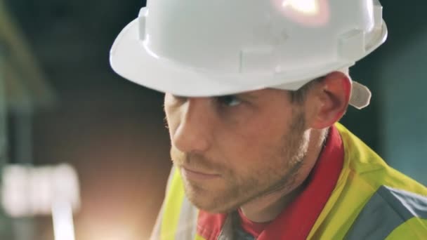 Vista lateral de la cara de trabajador barbudo en la fábrica de trabajo de metal — Vídeo de stock