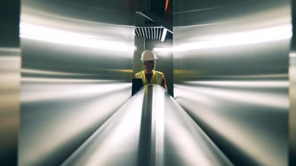 Engineer small figure behind huge rolling mill — Stock Video