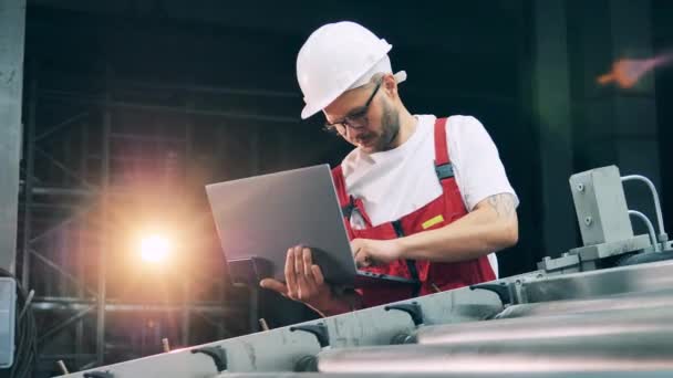 Engineer entering metal rolling information into laptop — Stock Video
