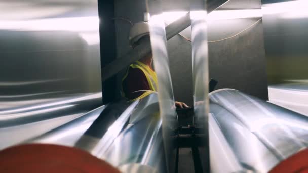 Engineer with laptop moving behind rolling mill — Stock Video