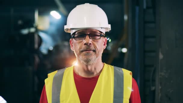 Ingeniero mirando recto y sonriendo en el haz de luz — Vídeo de stock