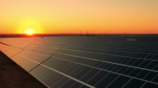 Vista aérea de uma enorme fazenda solar no pôr do sol brilhante — Vídeo de Stock