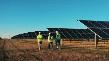 Profesyonel mühendisler yenilikçi projeyi tartıştılar. Güneş enerjisi uzmanları bir güneş enerjisi santralini izliyor