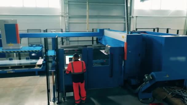 거대 한 절단 기계는 공장 근로자에 의해 관리되고 있습니다. 공장 내부. — 비디오