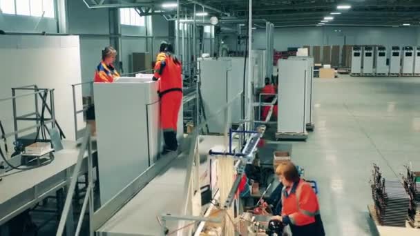 공장 직원들은 냉장고와 함께 일하고 있습니다. 공장 시설에서 생산 라인. — 비디오