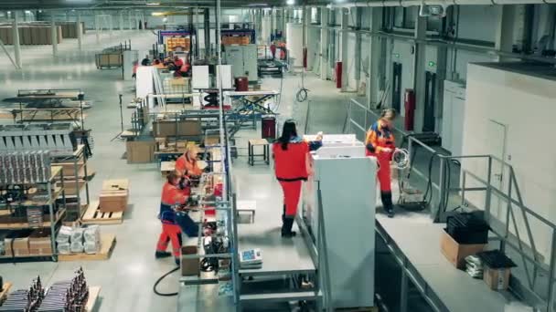 Robotnicy przemysłowi produkują lodówki. Linia produkcyjna w zakładzie produkcyjnym. — Wideo stockowe