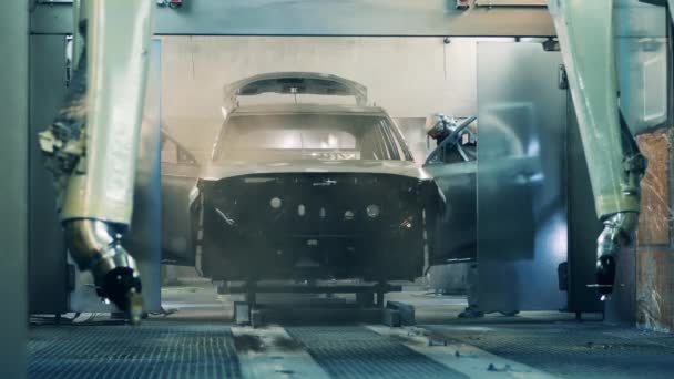 Fabrika işçileri araba fabrikasında bir araba cesedi boyuyor. — Stok video