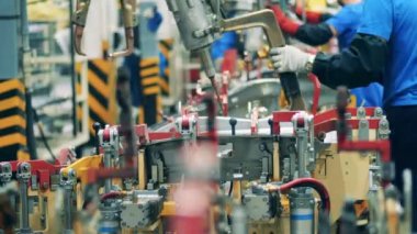 Araba fabrikası işçisi araba üretim fabrikasında kaynak makinesi kullanıyor. Endüstriyel fabrika, endüstriyel işçiler, otomobil fabrikası, araba üretim fabrikası.
