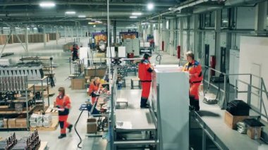 Bayan fabrika çalışanları buzdolabı üzerinde çalışıyor. Fabrika üretim hattındaki işçiler.