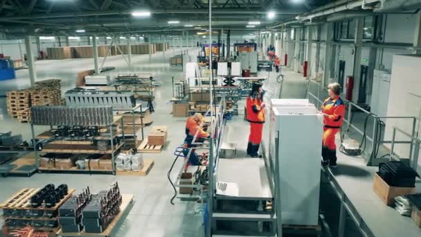 Línea de producción en una fábrica. Fábrica de refrigeración con empleados femeninos montando neveras — Vídeos de Stock