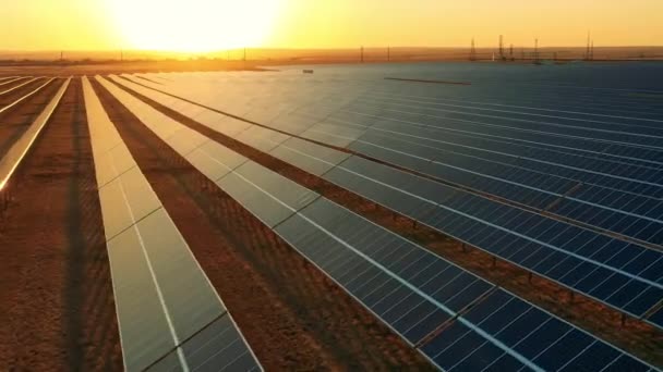 Drone shot van een zonne-energie boerderij bij heldere zonsondergang — Stockvideo