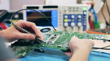 Osiloskopla elektronik aletleri test eden bir görevli. Eller yukarı..