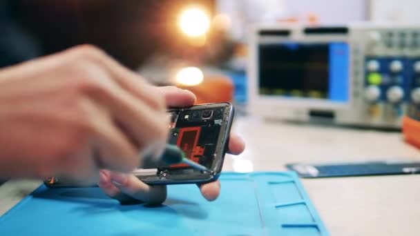 Reparador desarmando smartphone con destornillador. Primer plano de las manos. — Vídeos de Stock