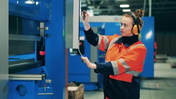 Fabrieksarbeider beheert een industriële machine via het scherm — Stockvideo