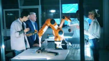 Araştırmacılar laboratuvarda bir robot cihazı analiz ediyorlar.